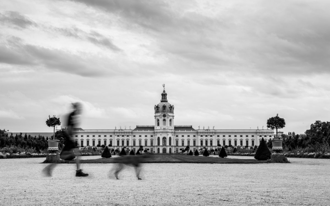 a large white building with a couple of people walking