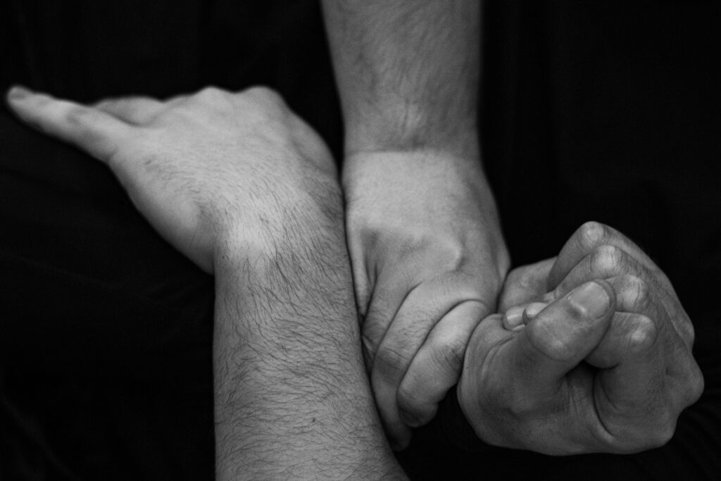Die Aufnahme zeigt eine intensive Momentaufnahme einer Kampfsportübung, vermutlich im Rahmen einer Reportage. Der Fokus liegt auf der körperlichen Intensität und dem unmittelbaren Kontakt zwischen den beteiligten Personen.